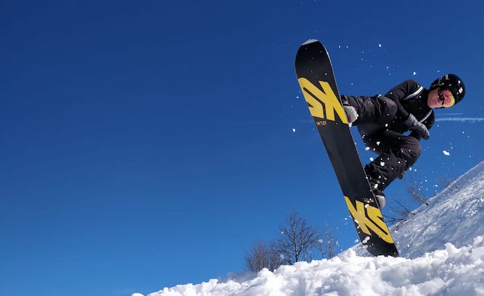 Un ado entrain de faire du snowboard en colonie de vacances ski et snow.